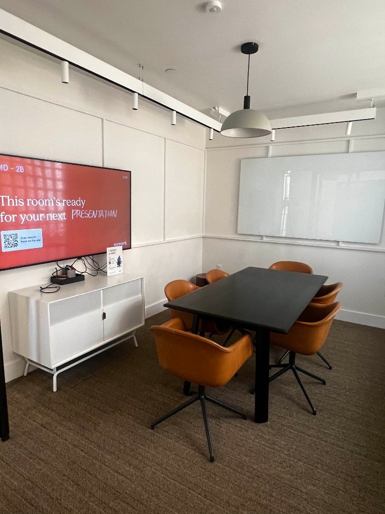 Modern training room with screen, whiteboard, and conference table